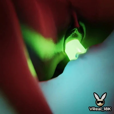 Two lesbians scissoring their way up recharging batteries using a green glowing double-ended dildo.